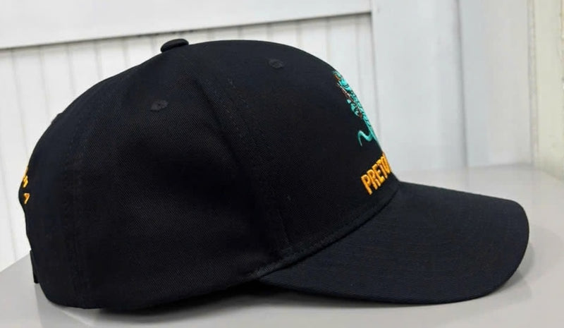 Pretow Mate™ from shecamp secure merchandise range features a Side profile view of the black baseball cap, highlighting its curved brim, structured front panels, stitched eyelets, and the side edge of the embroidered front Gecko logo and orange  branding.